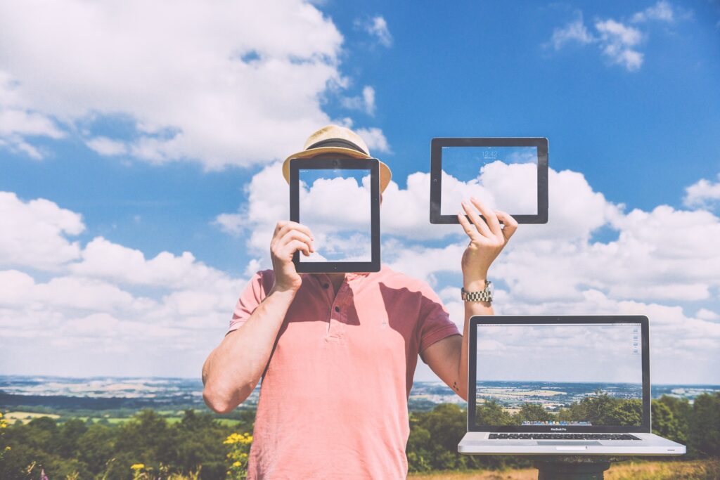 a man is trying three monitors with clouds