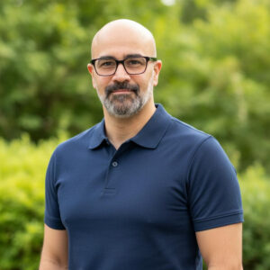 Smiling man in blue polo outdoors